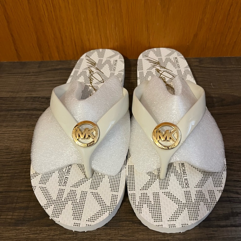 Michael Kors size 10, gold and white flip flops.